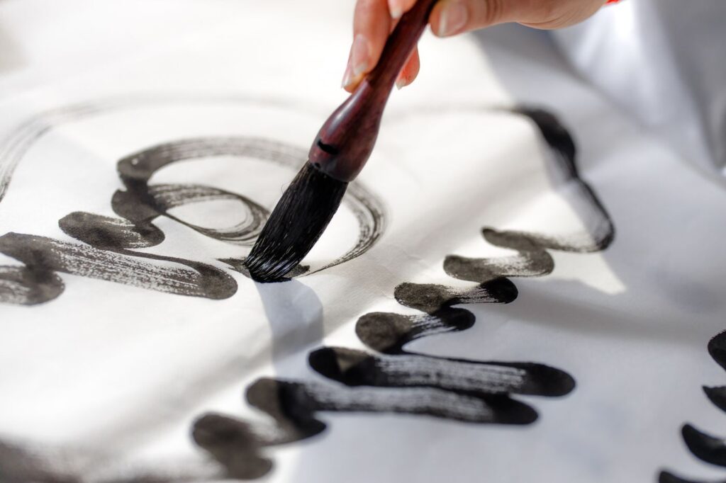 Brush writing Japanese calligraphy in black ink