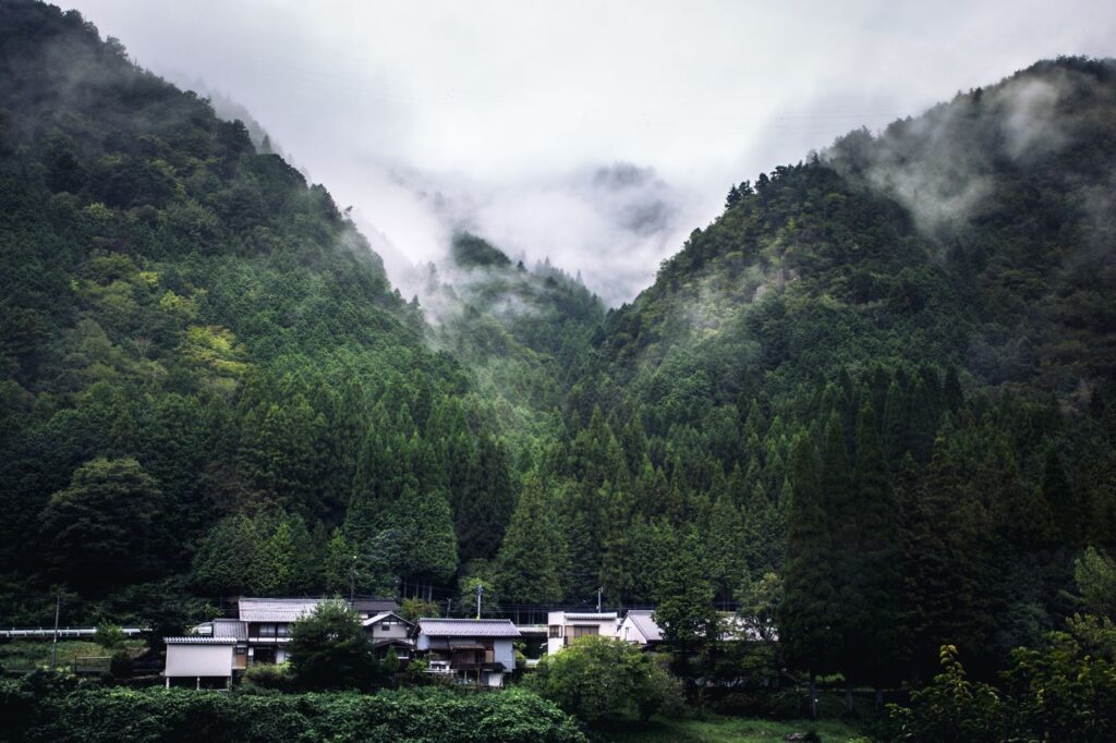 Small village among misty forested mountains in Japan