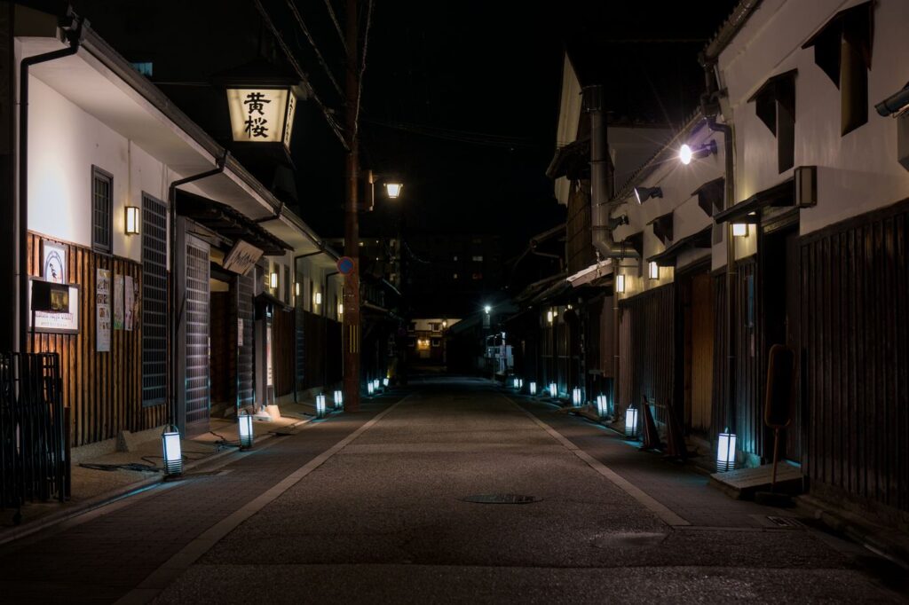Quiet traditional Japanese street at night lit by lanterns