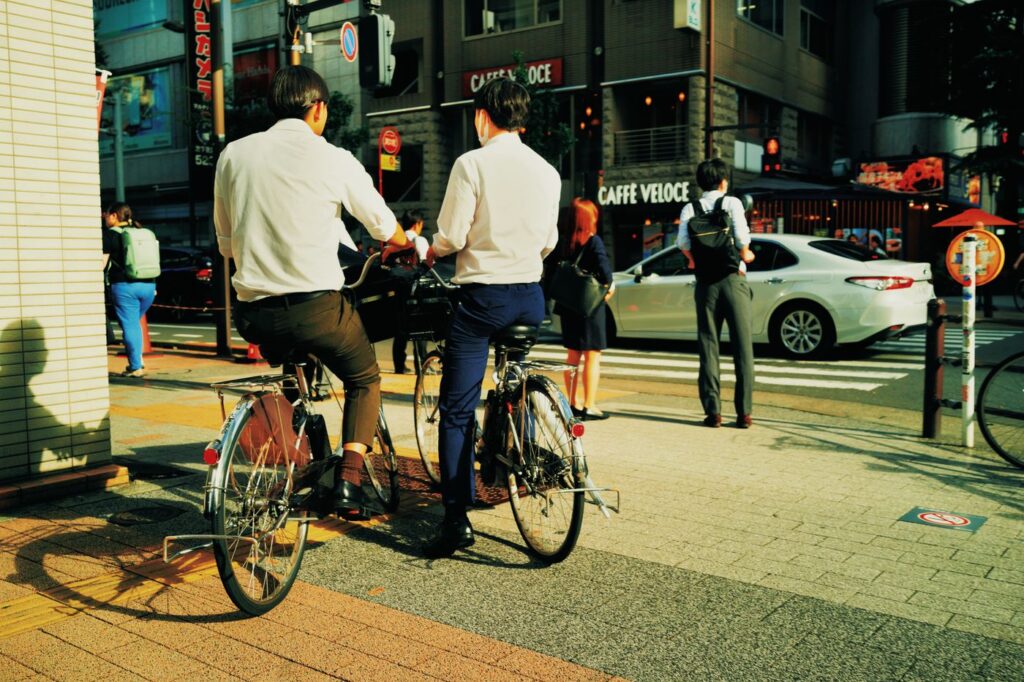 Office workers cycling through a Tokyo street