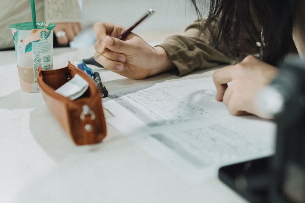 Student writing study notes at a desk in Tokyo